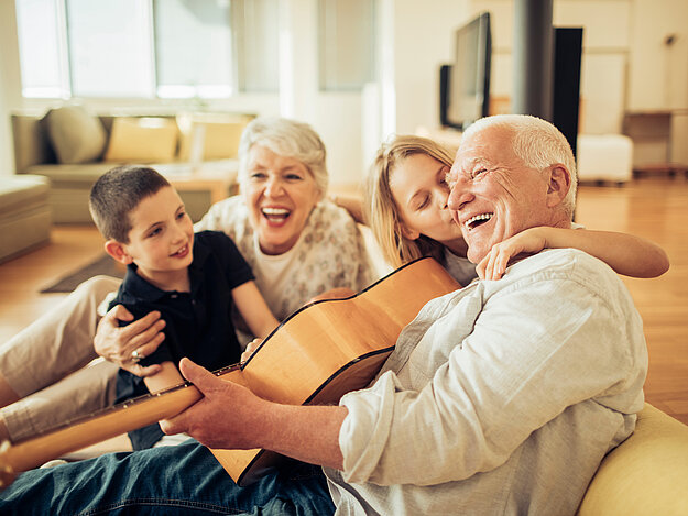Großeltern musizieren mit ihren Enkeln im Wohnzimmer